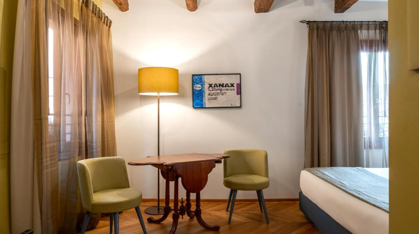 a bedroom with a large bed and a yellow chair at Excess Venice Boutique Hotel & Private Spa - Adults Only in Venice