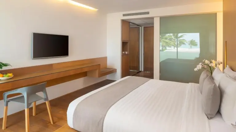a bedroom with a bed and a view of the ocean at Explorar Koh Samui - Adults Only Resort and Spa in Mae Nam