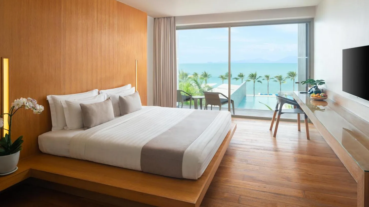 a couple sitting on a couch in a hotel room at Explorar Koh Samui - Adults Only Resort and Spa in Mae Nam