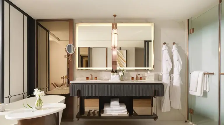 a hotel room with a large bed and a table at Fairmont Bangkok Sukhumvit in Bangkok