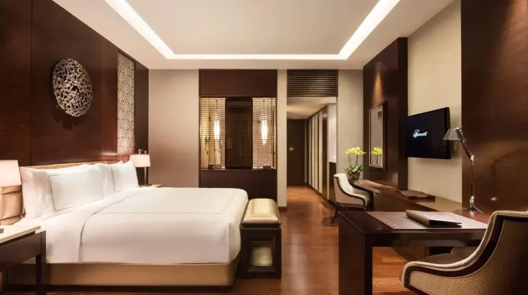 a man sitting in a hotel room looking out the window at Fairmont Jakarta in Jakarta