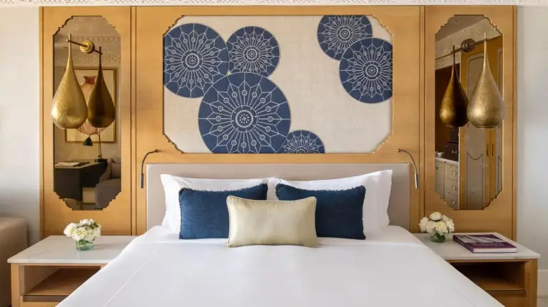 a bedroom with a large bed with blue and white pillows at Fairmont Tazi Palace Tangier in Tangier