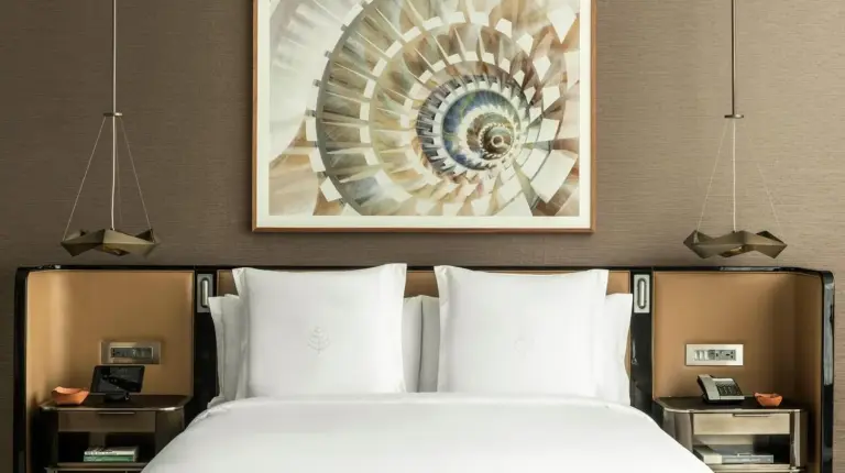 una cama en una habitación de hotel con un cuadro en la pared en Four Seasons Hotel Dubai International Financial Centre en Dubái