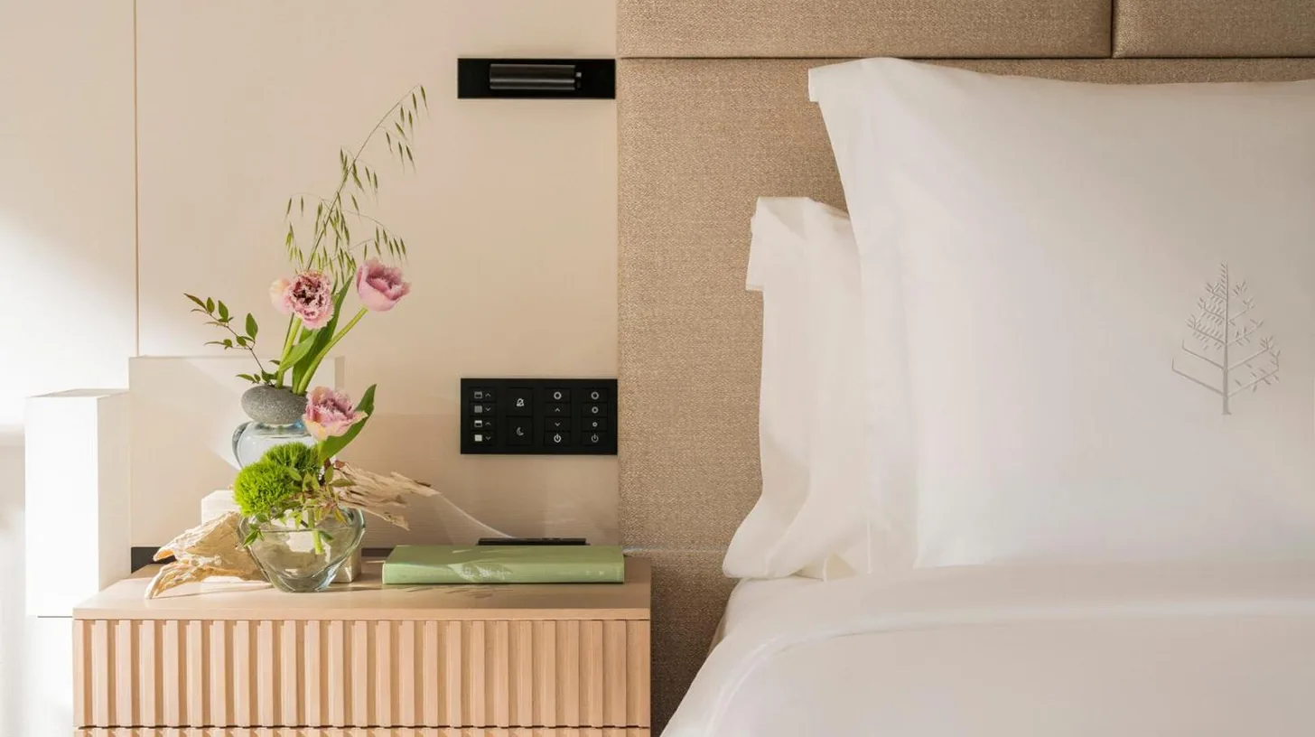 a bedroom with a bed and a night stand with flowers at Four Seasons Hotel Osaka in Osaka