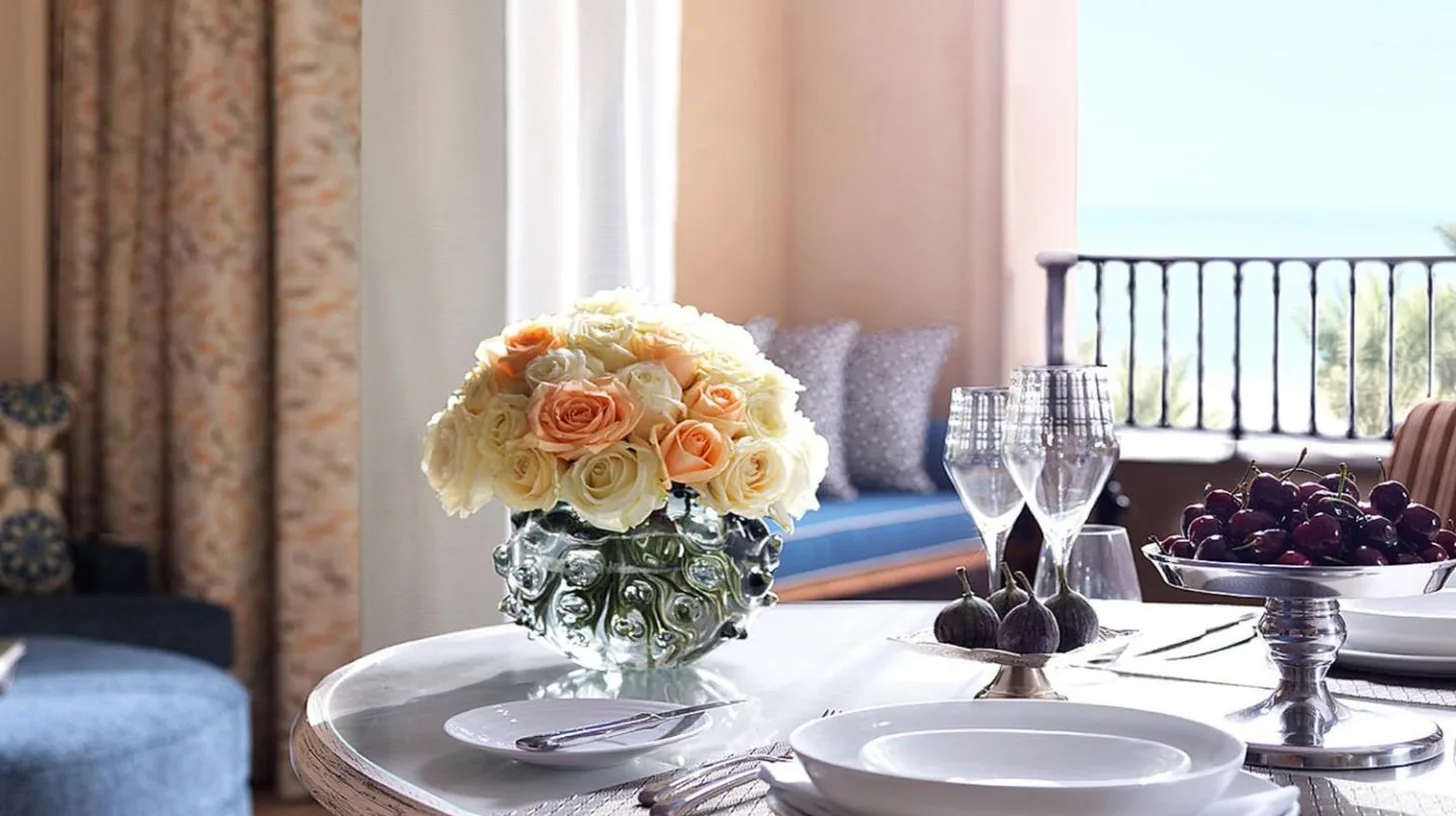 a dining room table with a vase of flowers on it at Four Seasons Resort Dubai at Jumeirah Beach in Dubai