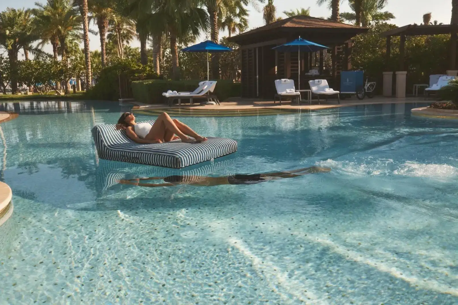 Four Seasons Resort Dubai at Jumeirah Beach pool area with guests relaxing