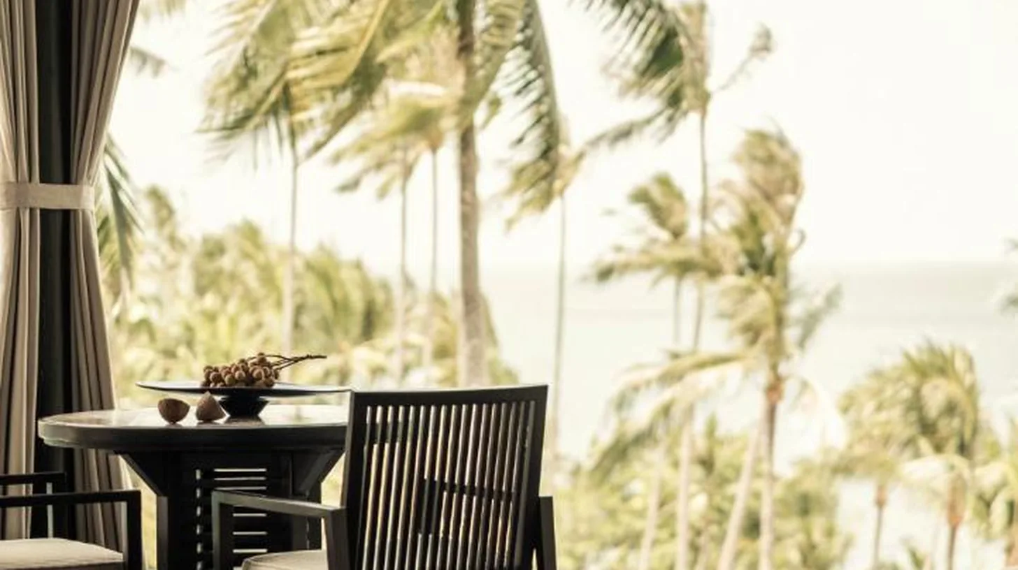 a dining room with a table and chairs and palm trees at Four Seasons Resort Koh Samui in Mae Nam