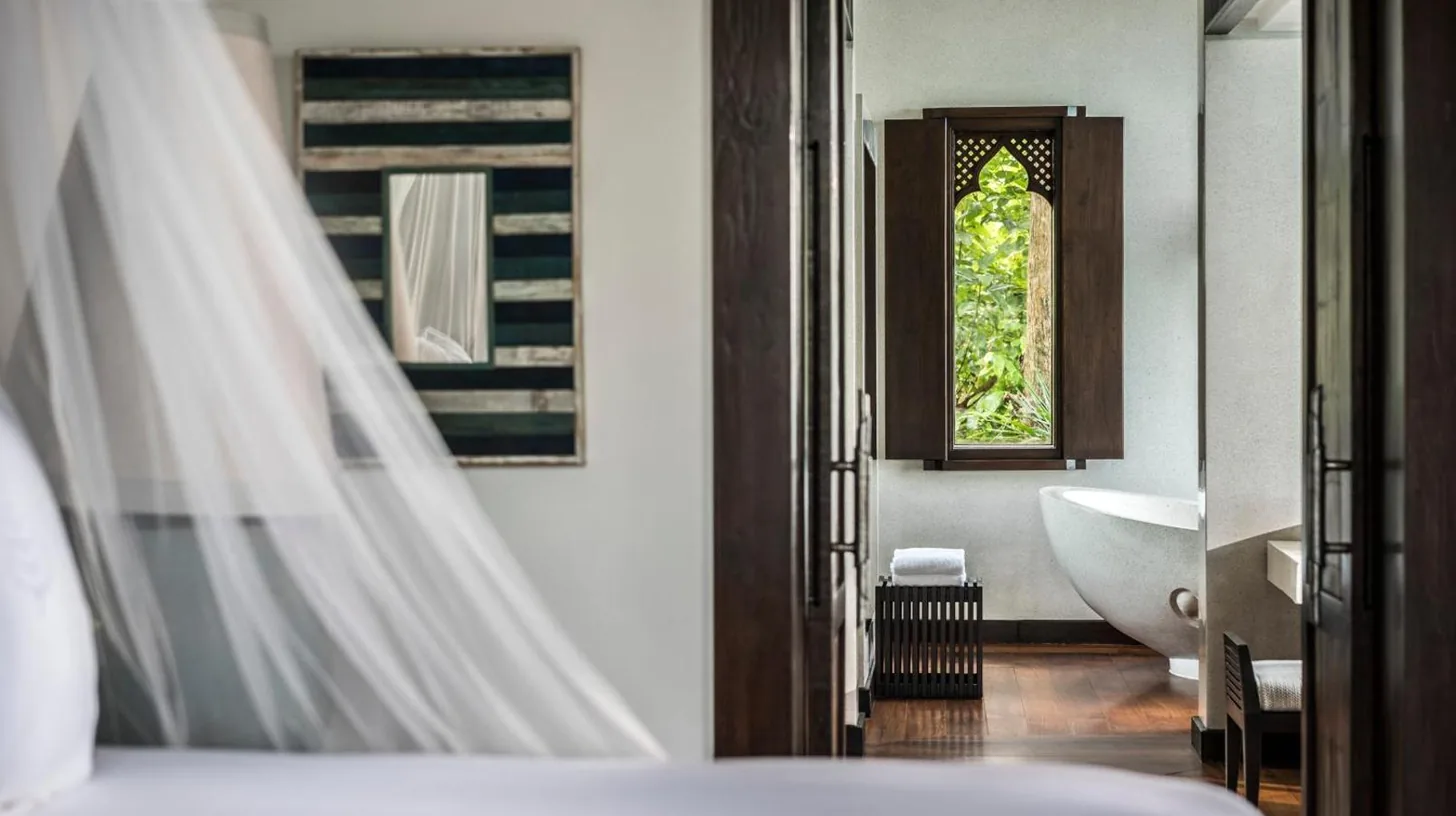 a bathroom with a white tub and a window at Four Seasons Resort Koh Samui in Mae Nam