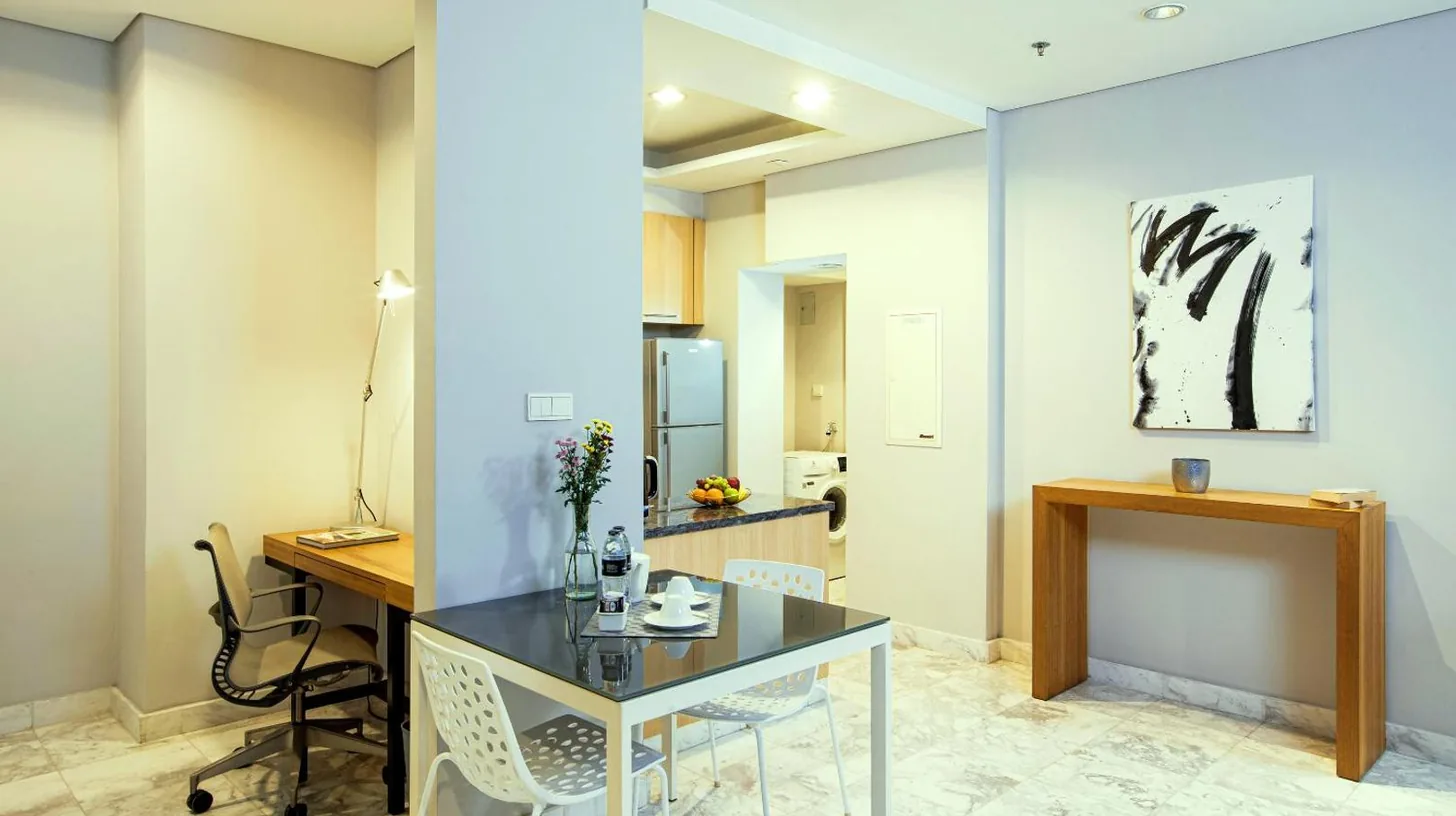 a dining room with a table and chairs at Fraser Residence Sudirman Jakarta in Jakarta