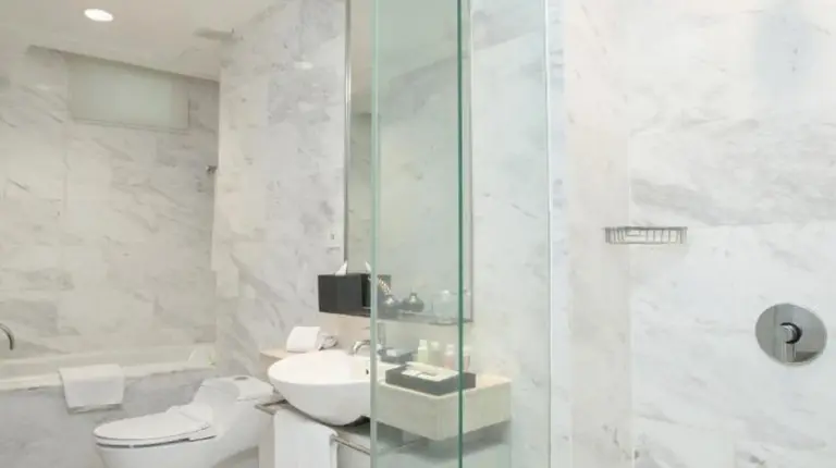 a bathroom with a glass shower and a toilet at Fraser Residence Sudirman Jakarta in Jakarta
