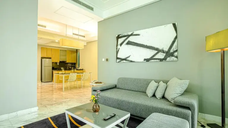 a living room with a couch and a table at Fraser Residence Sudirman Jakarta in Jakarta