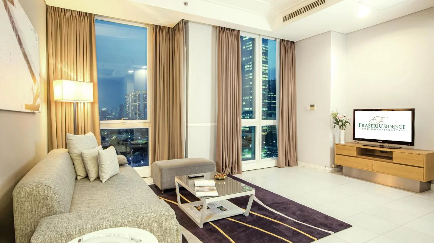 a hotel room with two beds and a large window at Fraser Residence Sudirman Jakarta in Jakarta