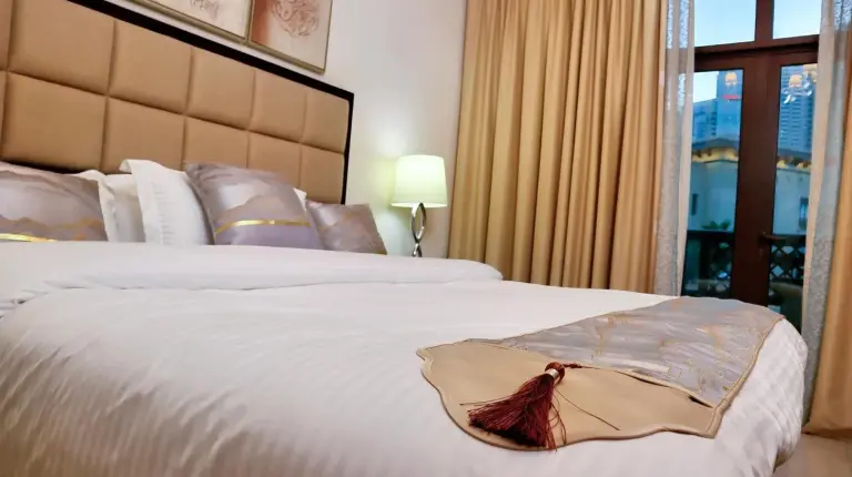 a bedroom with a large white bed with two lamps at Full View Burj Khalifa and Fountains -Souk Al Bahar- Dream View holiday Home Rental in Dubai