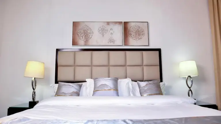 a bedroom with a large bed with white sheets and pillows at Full View Burj Khalifa and Fountains -Souk Al Bahar- Dream View holiday Home Rental in Dubai