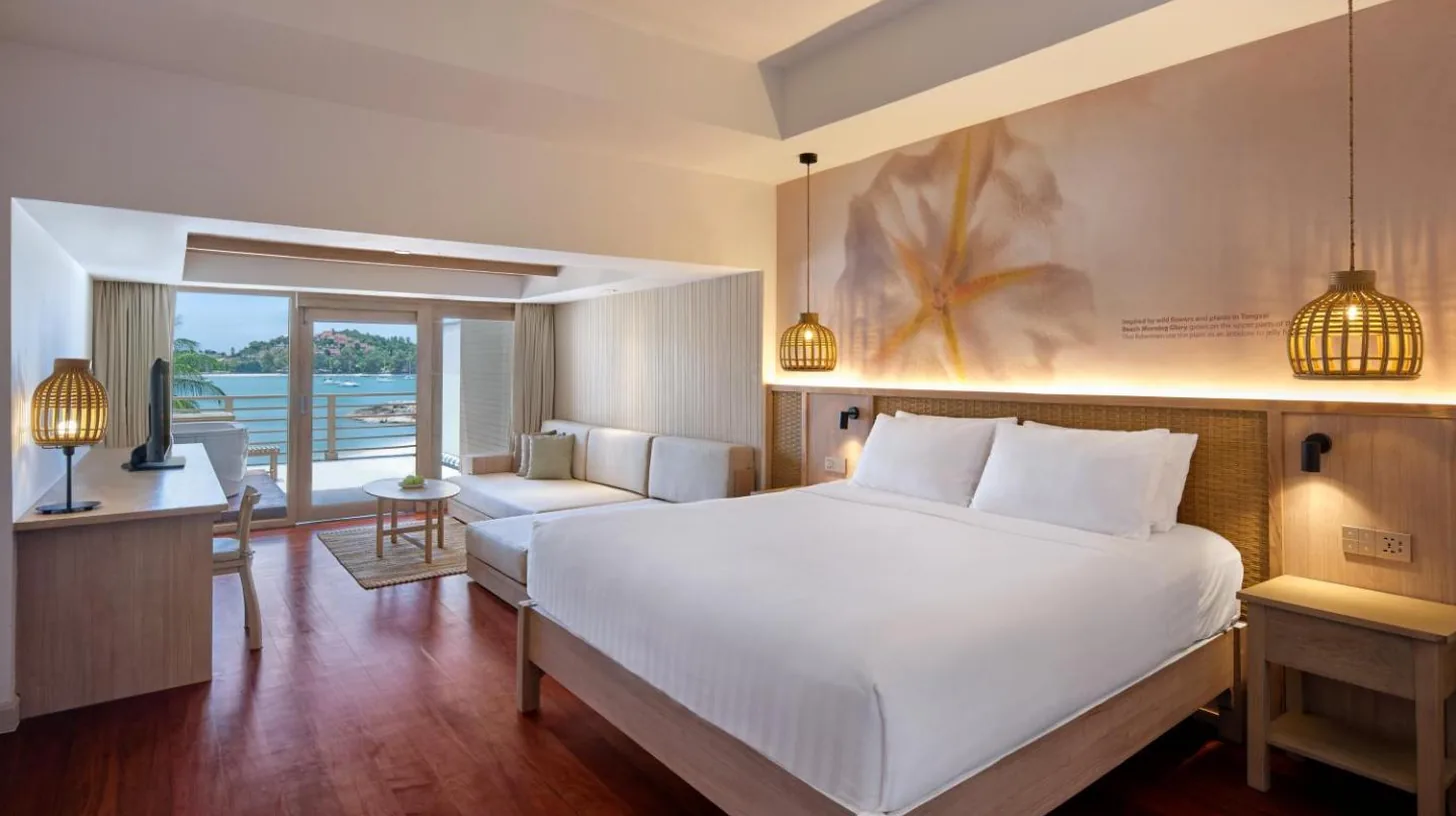 a bedroom with a large bed and a living room at Garrya Tongsai Bay Samui in Choeng Mon Beach
