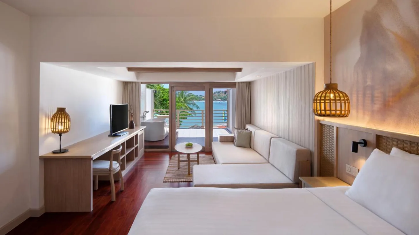 a bedroom with a bed and a living room at Garrya Tongsai Bay Samui in Choeng Mon Beach