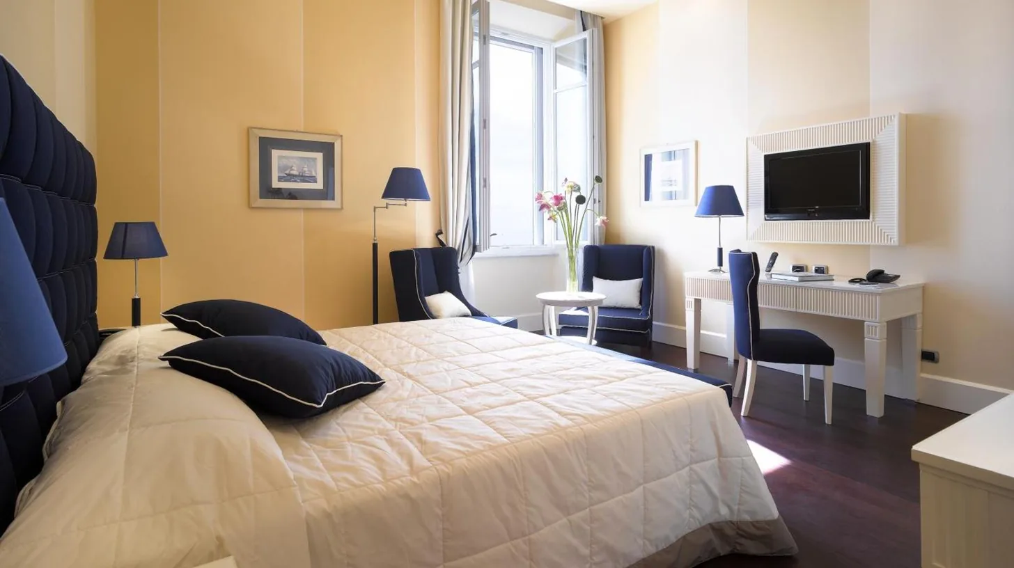 a bedroom with a bed and a desk and a computer at GH Palazzo Suite & SPA in Livorno