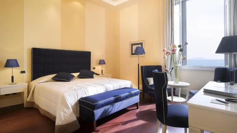 a bedroom with a bed and a table and chairs at GH Palazzo Suite & SPA in Livorno