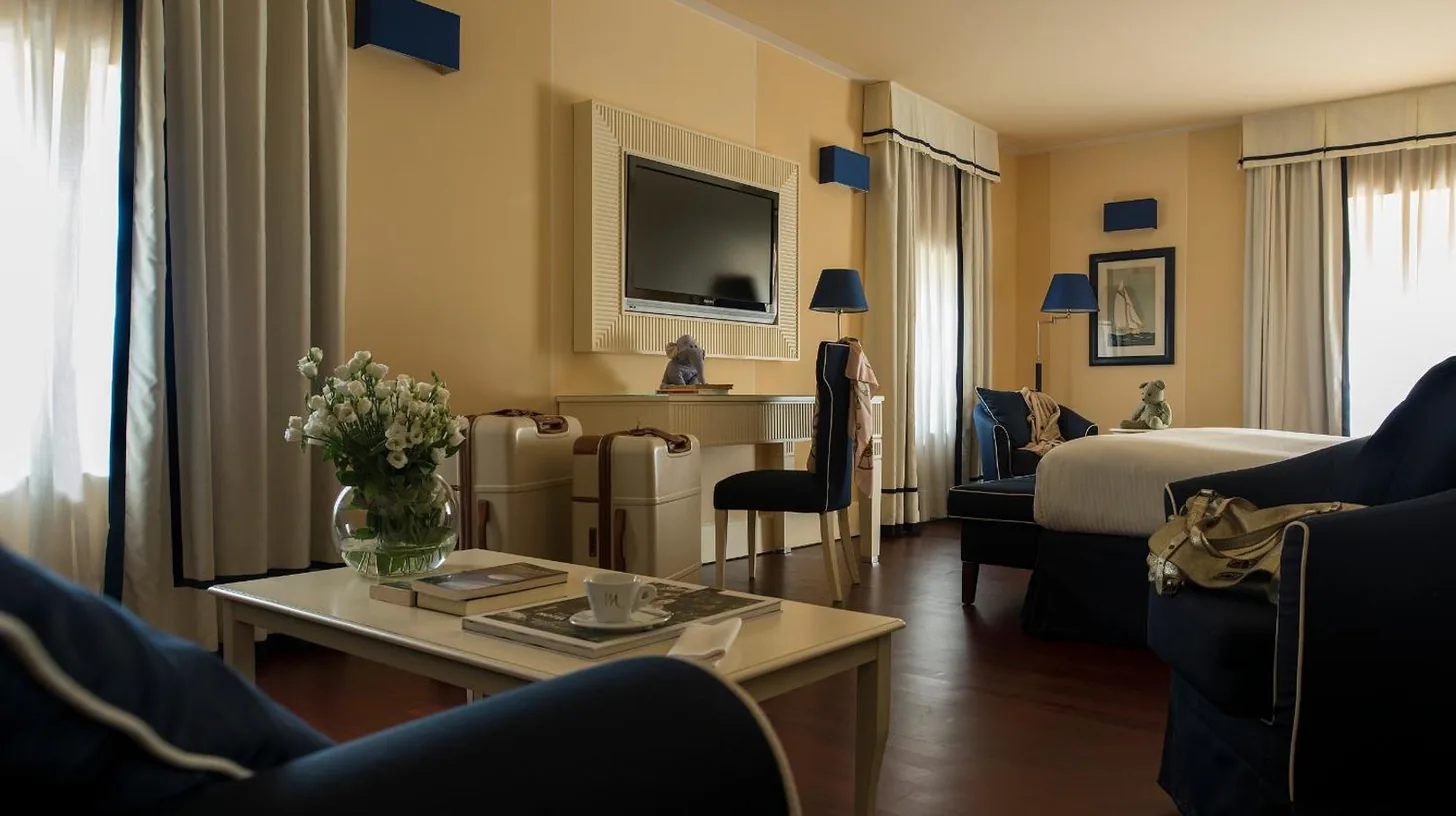 a hotel room with a bed and a living room at GH Palazzo Suite & SPA in Livorno