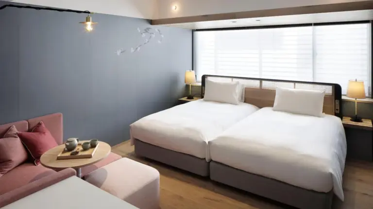 una habitación de hotel con dos camas y un sofá en GOOD NATURE HOTEL KYOTO en Kioto