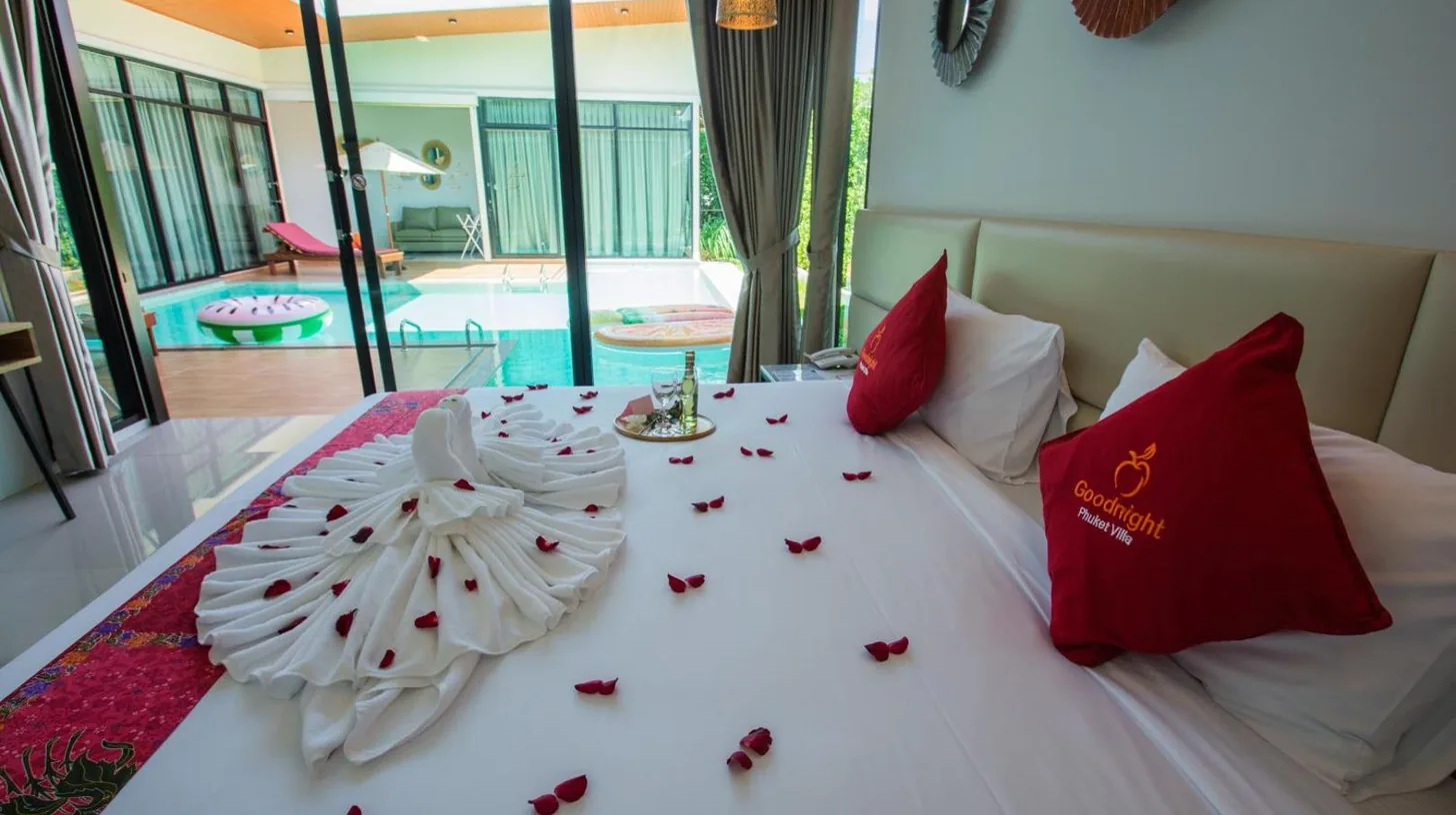 a bed with red and white decorations on it at Good Night Pool Villa Phuket in Phuket Town