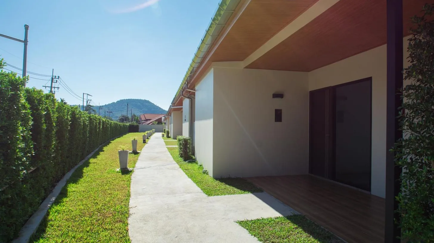 a sidewalk next to a house with a fence at Good Night Pool Villa Phuket in Phuket Town