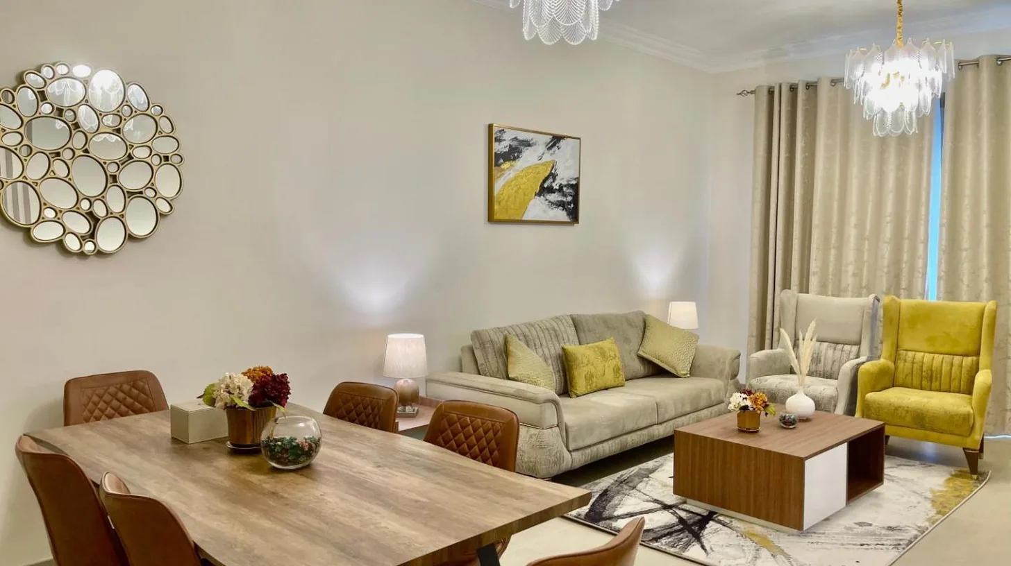 a living room with a table and a couch at GOODWOOD SUITES HOMES VACATION in Dubai