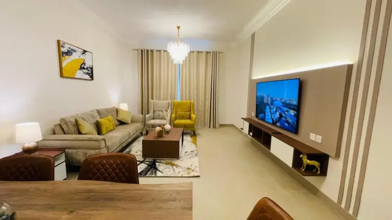 a living room with a couch and a tv at GOODWOOD SUITES HOMES VACATION in Dubai