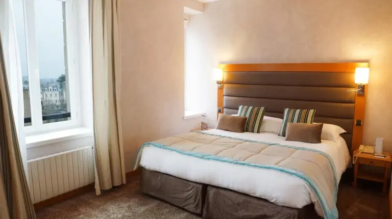 a bedroom with a large bed in front of a window at Grand Hôtel Des Thermes in Saint Malo