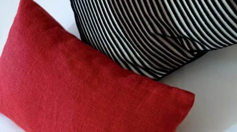 a red pillow next to a black and white at Grand Hôtel Des Thermes in Saint Malo