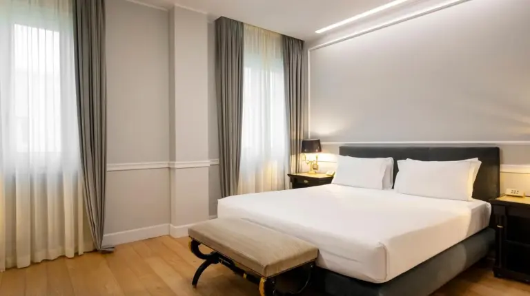 une chambre avec grand lit blanc et chaise au Grand Hotel Et Des Palmes Ã  Palerme