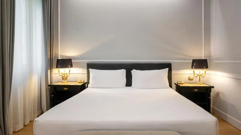 une chambre avec grand lit blanc et deux lampes au Grand Hotel Et Des Palmes Ã  Palerme
