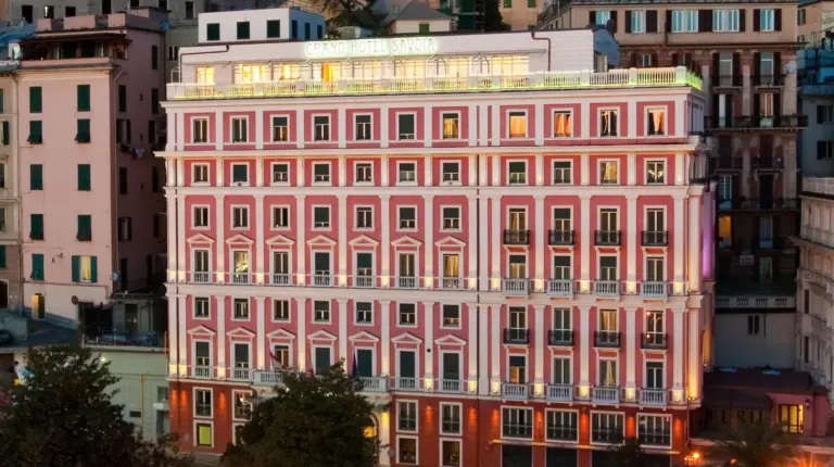 a pink building in the middle of a city at Grand Hotel Savoia Genova