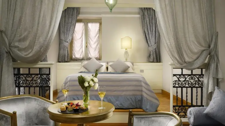a bedroom with a bed and a living room at Grand Hotel Savoia Genova