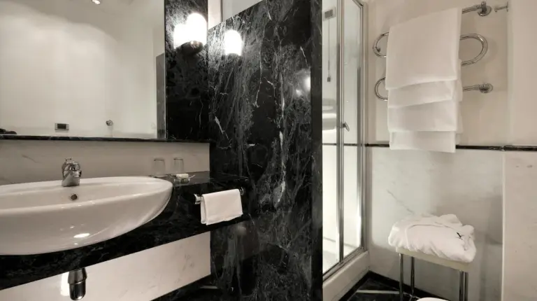 a black and white bathroom with a sink and a shower at Grand Hotel Vesuvio in Naples