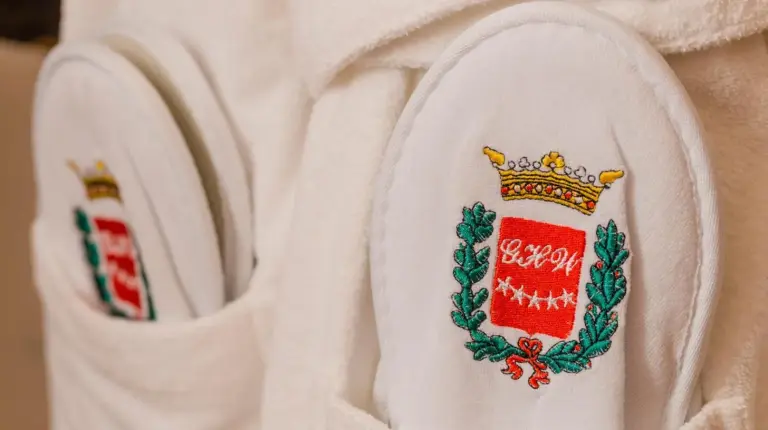 eine Nahaufnahme einer weißen Robe mit Krone im Grand Hotel Wagner in Palermo