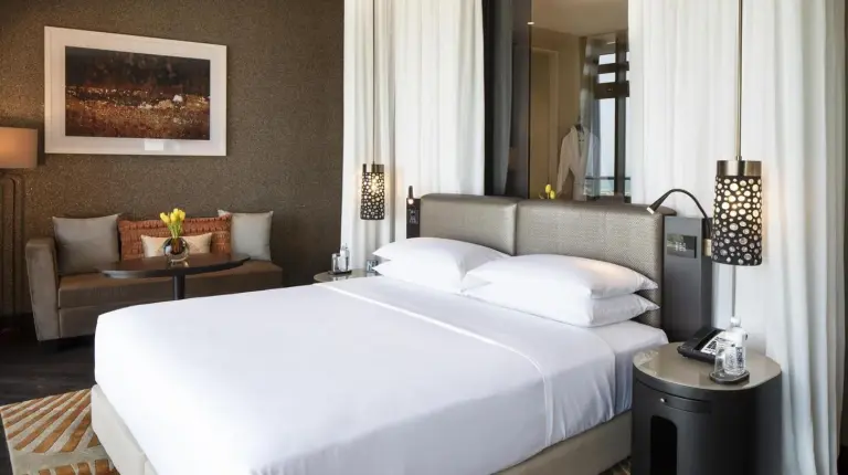 a bedroom with a large white bed and a couch at Grand Hyatt Abu Dhabi Hotel & Residences Emirates Pearl in Abu Dhabi