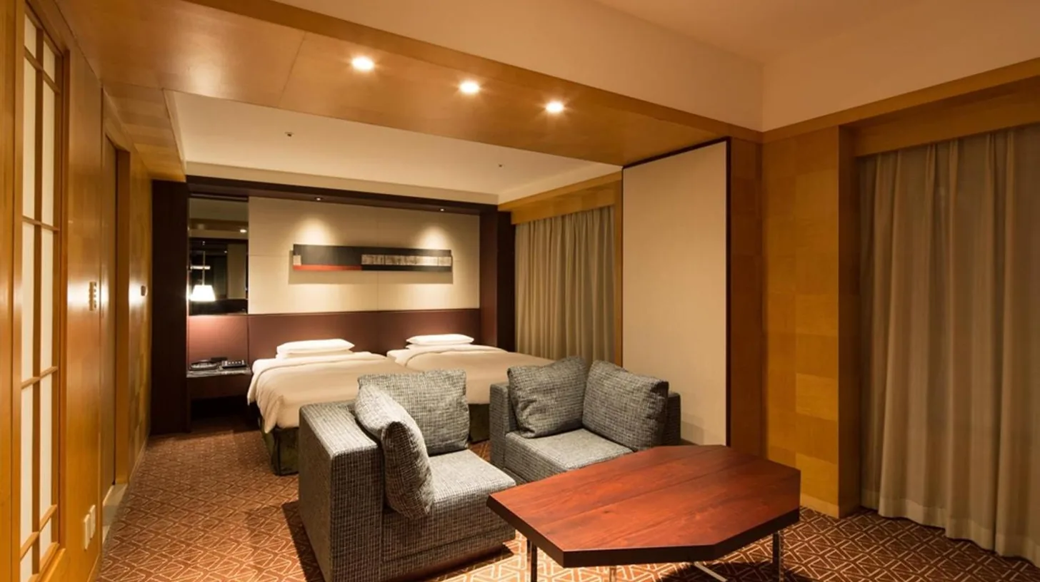 a hotel room with a bed and two chairs and a table at Grand Hyatt Fukuoka in Fukuoka