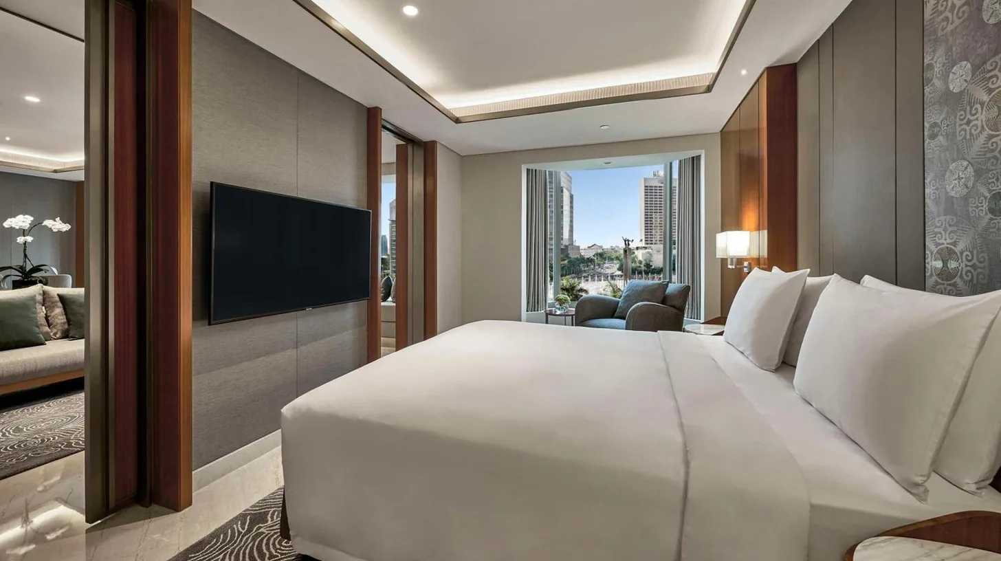 a bedroom with a large white bed and a television at Grand Hyatt Jakarta in Jakarta