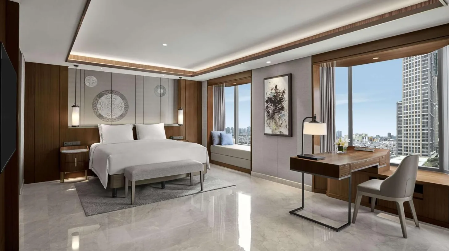 a hotel room with a bed and a desk and a desk at Grand Hyatt Jakarta in Jakarta