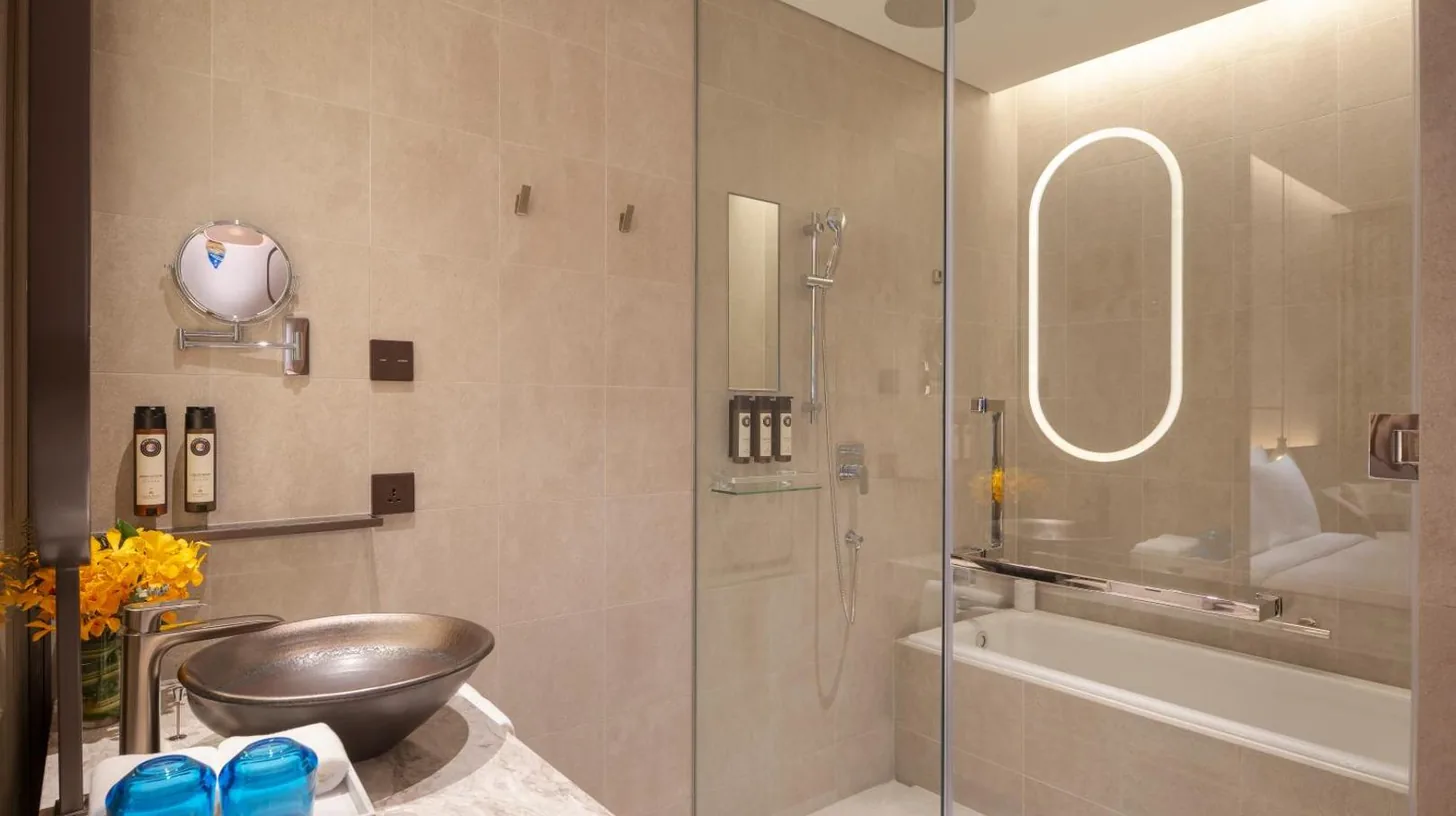 a bathroom with a shower and a sink and a tub at Grand Nikko Bangkok Sathorn in Bangkok