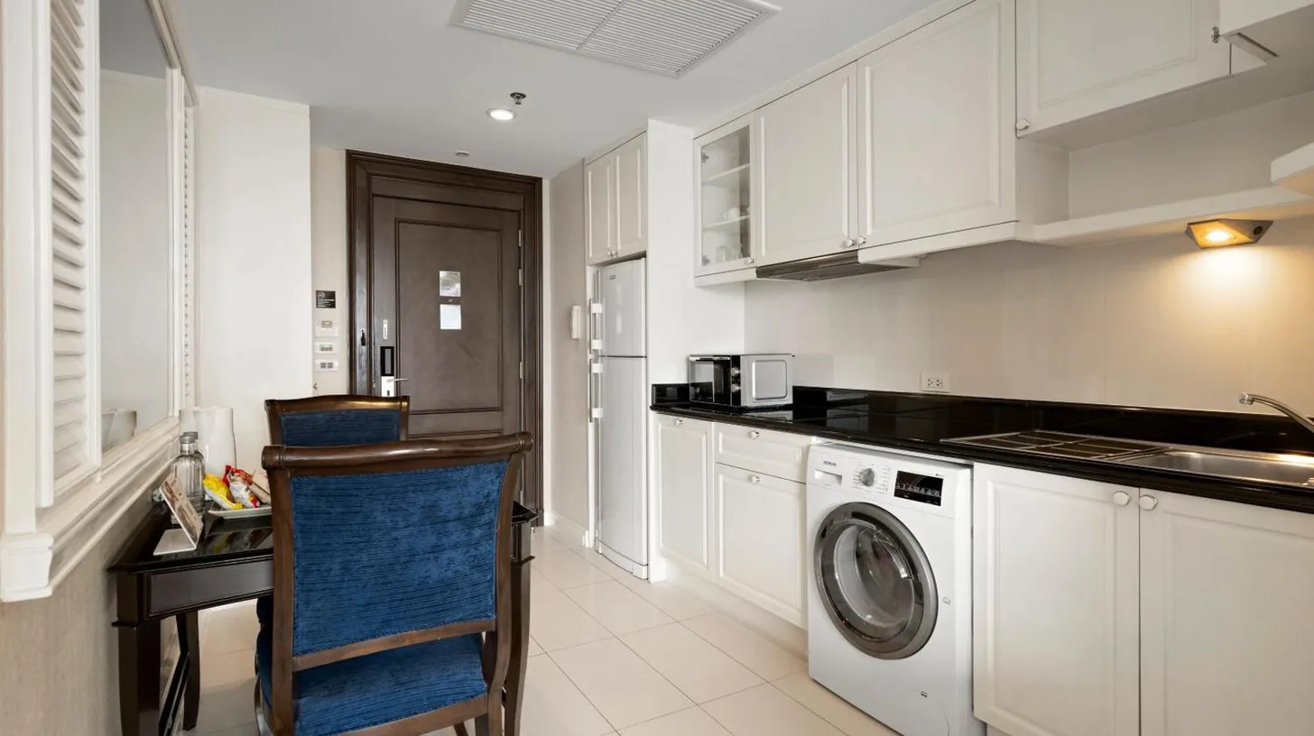 a white kitchen with a washing machine in it at Grande Centre Point Hotel Ratchadamri Bangkok in Bangkok