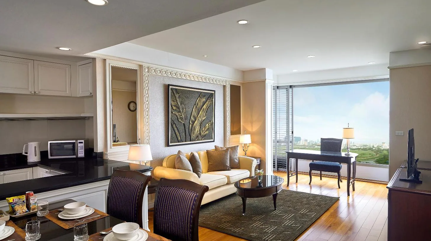 a living room with a couch and a table at Grande Centre Point Hotel Ratchadamri Bangkok in Bangkok