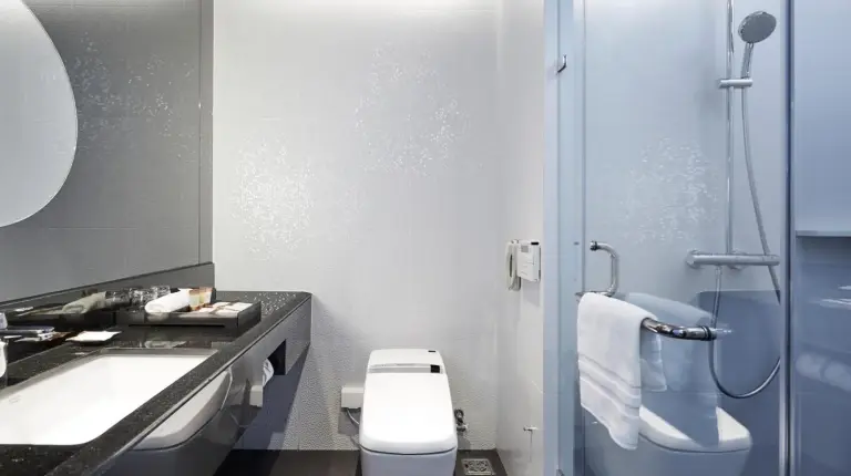 a bathroom with a sink and a toilet and a mirror at Grande Centre Point Pattaya in Pattaya Central