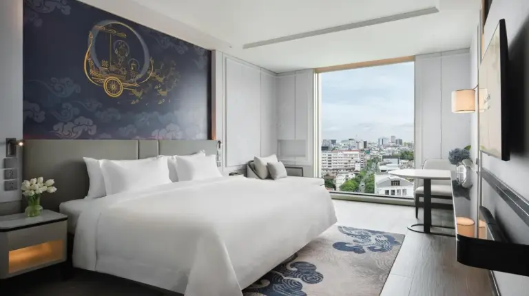 a bedroom with a large white bed and a large window at Grande Centre Point Surawong Bangkok in Bangkok