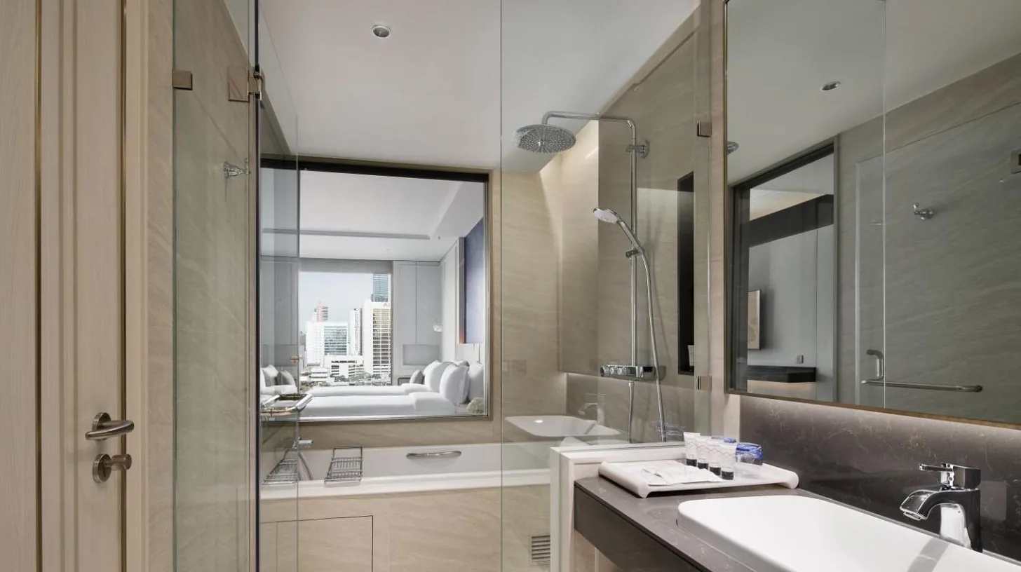a bathroom with a shower and a sink and a mirror at Grande Centre Point Surawong Bangkok in Bangkok