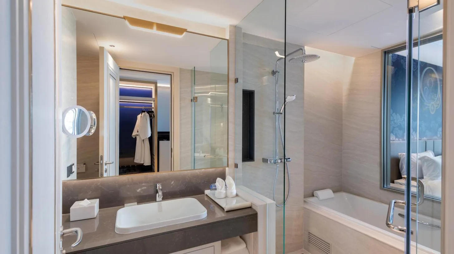 a bathroom with a sink and a shower and a tub at Grande Centre Point Surawong Bangkok in Bangkok