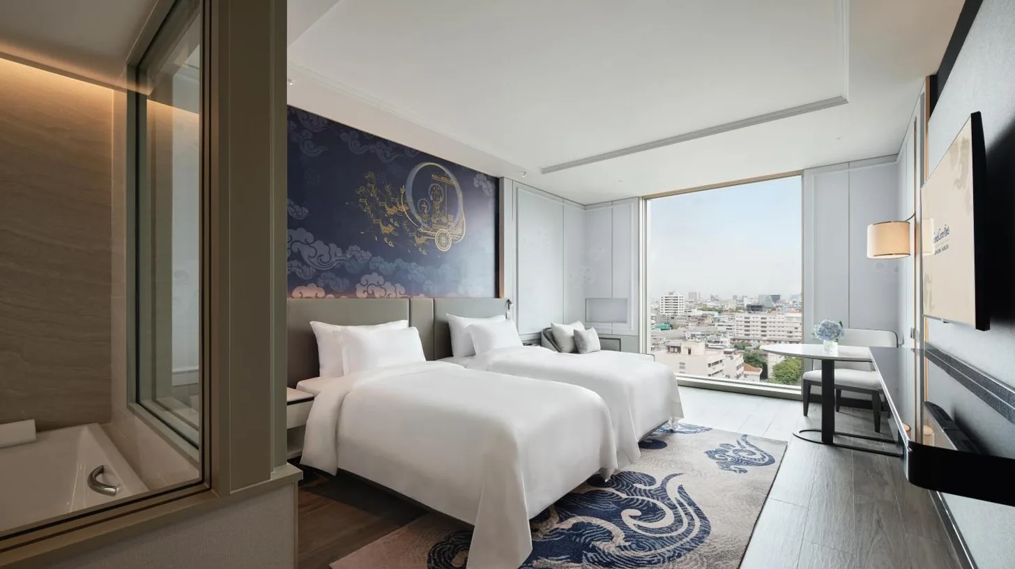 a bedroom with a large white bed and a window at Grande Centre Point Surawong Bangkok in Bangkok