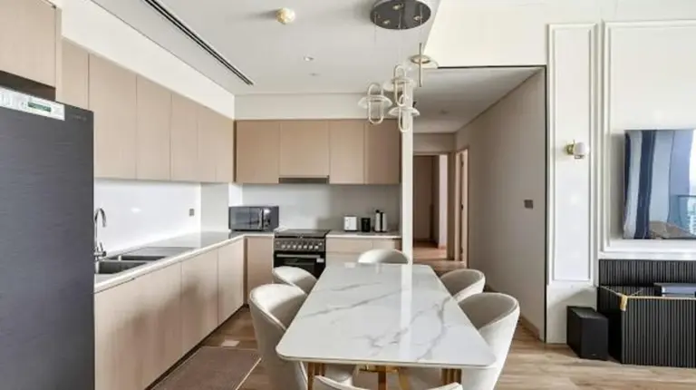 a kitchen with a table and chairs in a room at Grande Signature Residences in Dubai