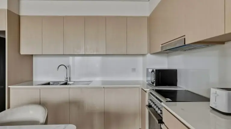 a kitchen with a sink and a stove top oven at Grande Signature Residences in Dubai
